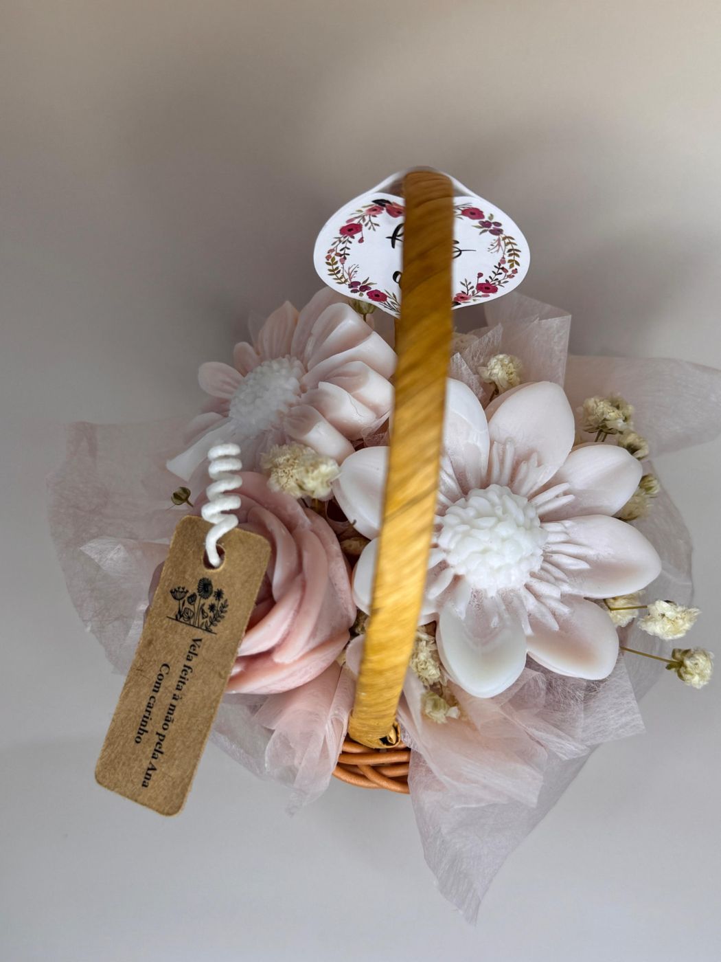 Cesto com bouquet de velas florais em tons pastel visto de cima