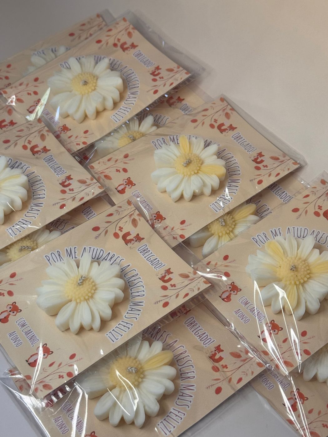 Lembranças com vela em forma de margarida embaladas individualmente com cartão personalizado